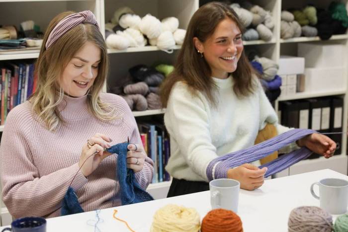 Iloisia ihmisiä käsitöiden parissa tuftauskurssilla